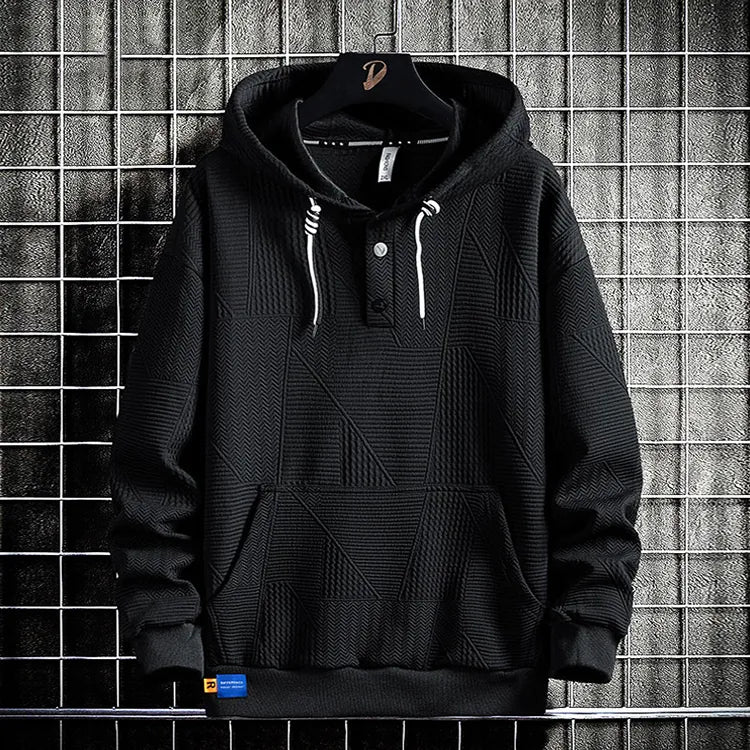 Hdfish men oversized black geometric triangle jacquard henley hoodie back view, mixed texture hooded sweatshirt hanging on metal grid rack